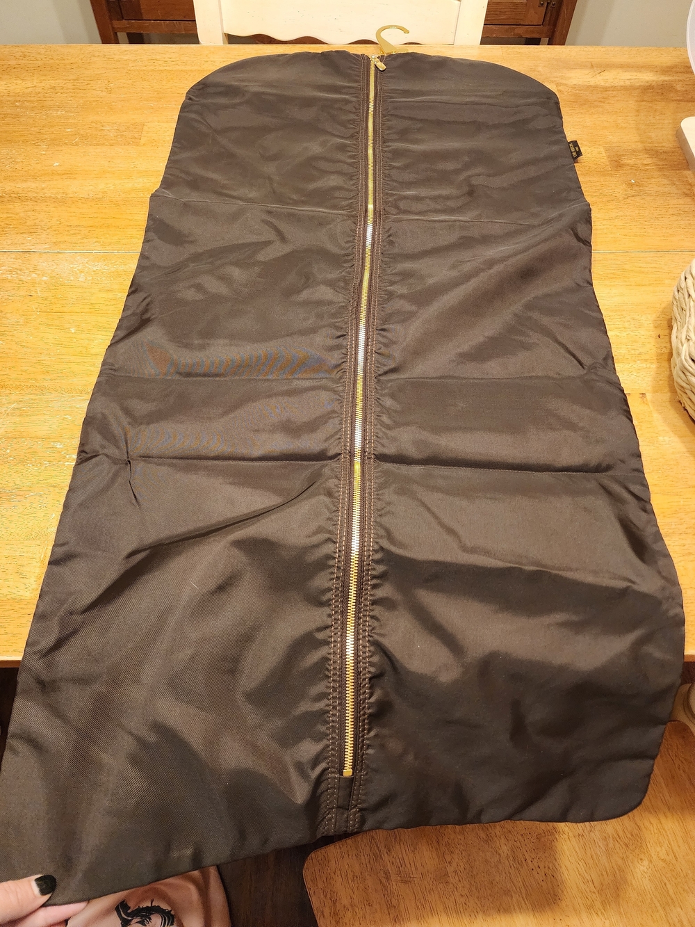 brown Louis Vuitton nylon garment cover with a gold-tone front zipper and Hanger